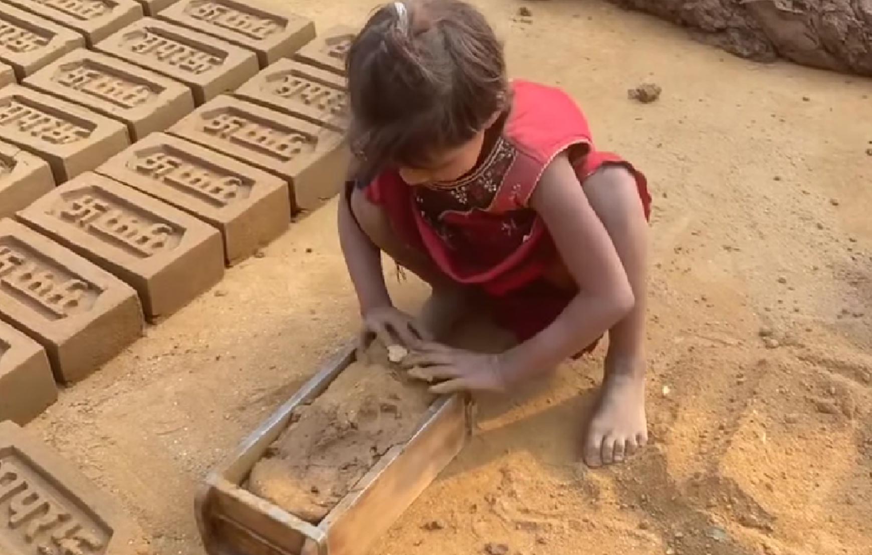 A child making bricks out of sand.